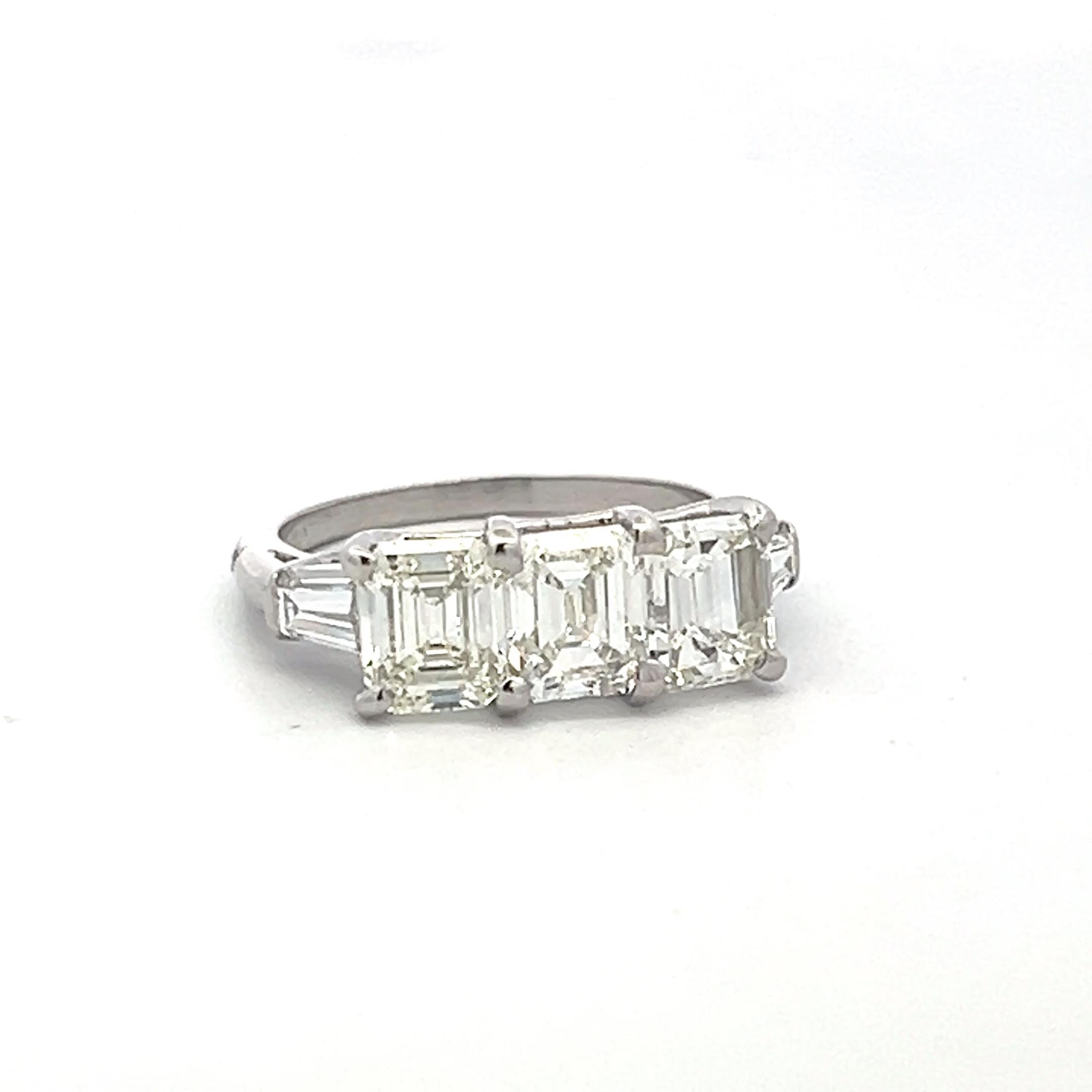 Vintage White Platinum Three-Stone Ring with 2.91 Carat Emerald Cut Diamonds GIA