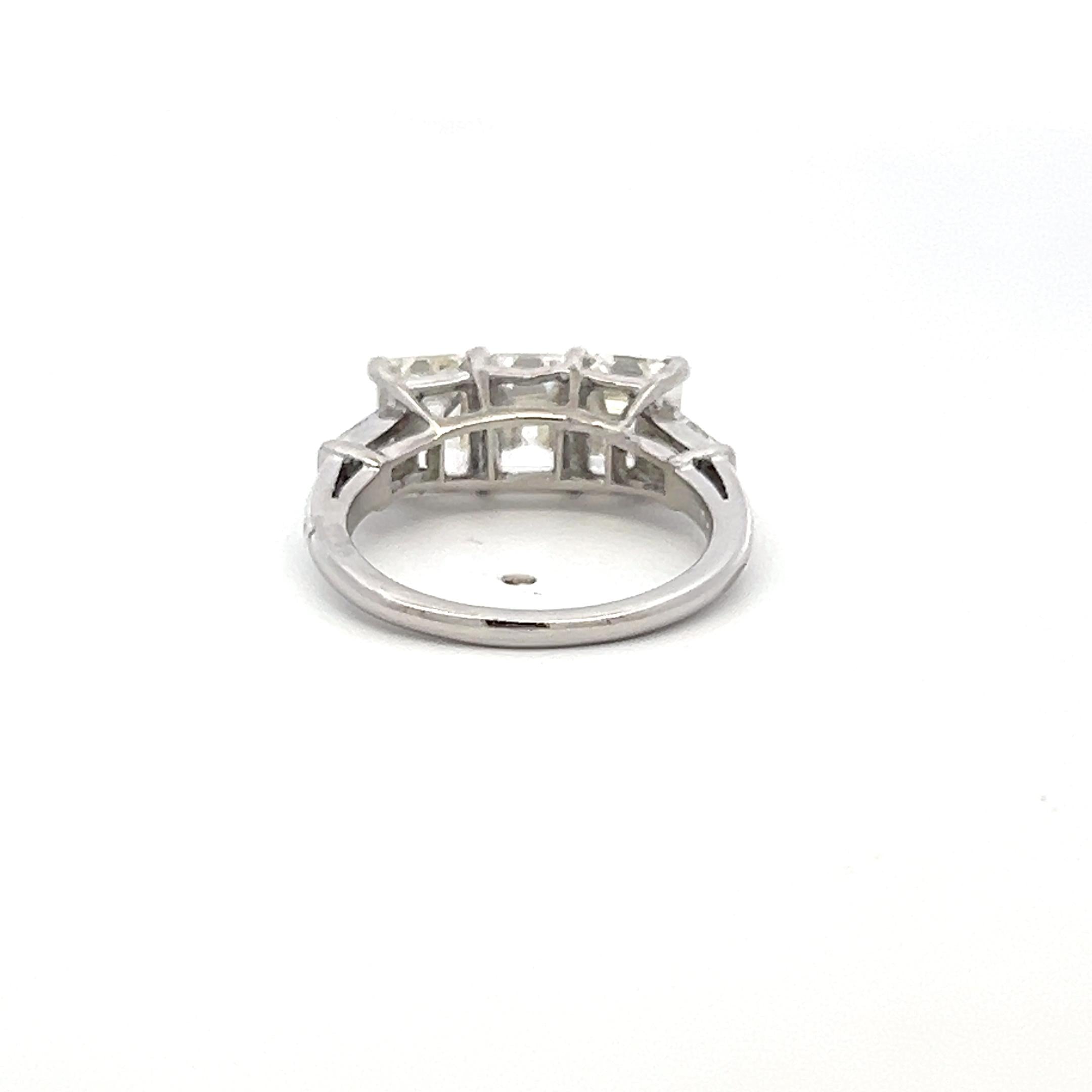 Vintage White Platinum Three-Stone Ring with 2.91 Carat Emerald Cut Diamonds GIA